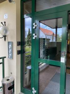a green door with a view of a house at RESIDENZ AM BERG in Hartmannsdorf