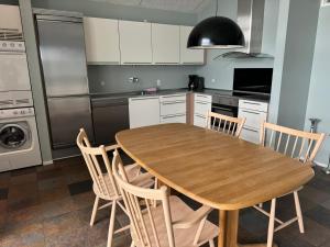 a kitchen with a wooden table and chairs at Hvide Sande Hotel in Hvide Sande