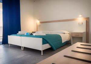 a bedroom with a bed with a green blanket at Resort Beach Cala Goloritzè in Santa Maria Navarrese