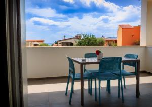 una mesa y sillas en un balcón con vistas en Resort Beach Cala Goloritzè, en Santa Maria Navarrese