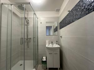 a bathroom with a shower and a sink at Apartamenty Sunny Stay Jastarnia in Jastarnia