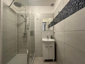 a bathroom with a shower and a sink and a mirror at Apartamenty Sunny Stay Jastarnia in Jastarnia +29 photos