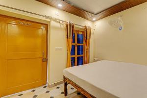 een slaapkamer met een bed, een deur en een raam bij Hotel O Home Shyama Lodge in Ayodhya