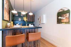 a kitchen with a wooden counter and orange chairs at Cocon Coloré - Studio pour 2 30min de Paris in Chevilly-Larue