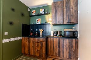 a kitchen with wooden cabinets and a microwave at Cocon Coloré - Studio pour 2 30min de Paris in Chevilly-Larue +3 photos
