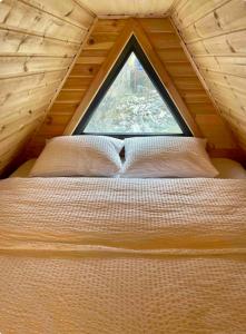 Kazbegi Kuro Cottages في كازباجي: سرير في غرفة مع نافذة