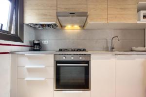 a kitchen with white cabinets and a stove top oven at Bed&BCN Forum II in Sant Adria de Besos
