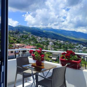 stół i krzesła na balkonie z kwiatami w obiekcie Vladimir Estate Hotel w Gjirokastrze