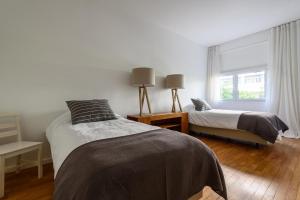1 dormitorio con 2 camas y ventana en Apartamento entre Copacabana e Ipanema en Río de Janeiro
