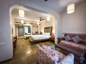 een woonkamer met een bed en twee banken bij Riva Beach Resort in Mandrem