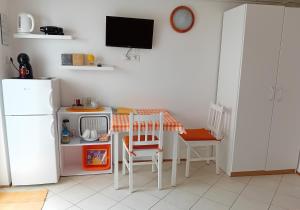 een keuken met een kleine tafel en een witte koelkast bij Apartma Gorjan in Tolmin