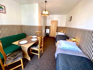 a room with two beds and a table and a couch at Ogrodowe zacisze in Jastrzębia Góra