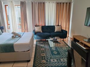 a living room with a bed and a couch at Tevin Nest 2 in Sandton +14 photos