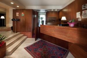 a lobby with a reception desk and a rug at Hotel Mariani in Iesi