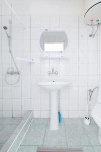 a white bathroom with a sink and a shower at Ogrodowe zacisze in Jastrzębia Góra +16 photos