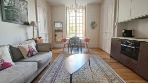a living room with a couch and a table at LA MAISON CANONIALE luxe et charme au coeur de Tours in Tours