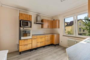 Una cocina con gabinetes de madera y microondas. en Aparthotel am Stadtpark, en Bad Sachsa