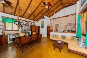 eine Küche und ein Wohnzimmer mit einem Sofa und einem Tisch in der Unterkunft Casa Yosi, Beach Front Piece of Heaven in San Juan del Sur