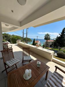 a patio with a table and chairs and a view of the ocean at Navy View in Paleo Tsifliki