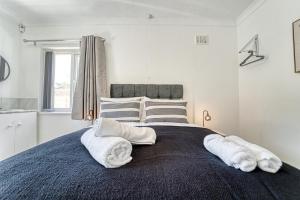 een slaapkamer met een groot bed en handdoeken bij Guest Homes - Chester House Retreat in Kidderminster