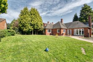 una casa con una pelota en el césped en el patio en Guest Homes - Chester House Retreat en Kidderminster
