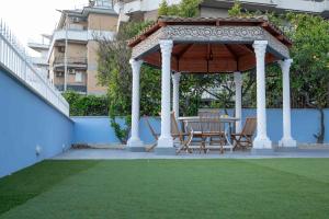 a gazebo with a table and chairs on a lawn at DIMORA BORDIN Luxury Aparthotel Animali ammessi in Nettuno
