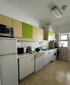 a kitchen with white appliances and green cabinets at Mira T1 Apartment in Carvoeiro +6 photos