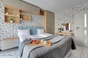 a bedroom with a bed with a tray of fruit on it at Lion Apartments - Angielska Grobla City Center in Gdańsk