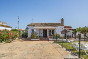 una casa bianca con una recinzione davanti di Chalet Villa Ariza a Cadice