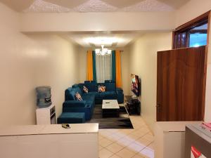 ein Wohnzimmer mit einem blauen Sofa in einem Zimmer in der Unterkunft Romantic 1Bedroom Gateway in Kinoo in Kikuyu