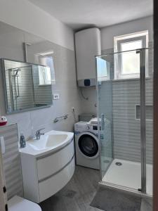 a bathroom with a sink and a washing machine at Apartment Antea in Šibenik +58 photos