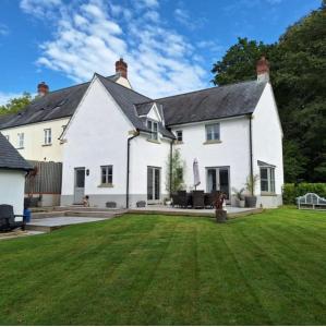 uma casa branca com um relvado à frente em Beautiful 4-bed home, Hot Tub & Stunning Views! em Abergavenny