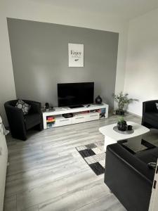 a living room with a couch and a television at Ferienhaushälfte Knobloch in Oberhausen