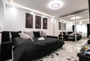 a living room with a bed and a mirror at Black&White mountain - ADULTS ONLY in Petroşani
