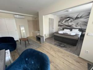 a bedroom with a bed and a living room with a couch at Brill Hotel Békéscsaba in Békéscsaba