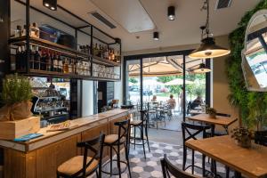 a bar in a restaurant with tables and chairs at Seven Town House Boutique Hotel in Locarno
