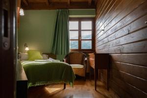 Schlafzimmer mit einem Bett, einem Fenster und einem Schreibtisch in der Unterkunft Apartamentos Rurales San Feliz in Pola de Lena