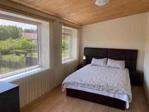 a bedroom with a bed and a large window at Ošupio kiemelis in Šventoji