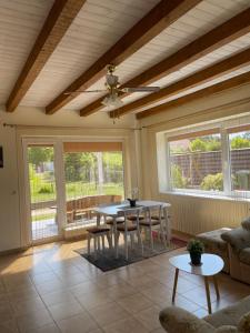 a living room with a ceiling fan and a table at Ošupio kiemelis in Šventoji
