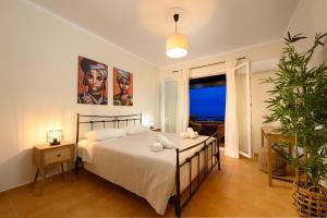a bedroom with a bed and a large window at Corfu Dream Holidays Villas in Glyfada