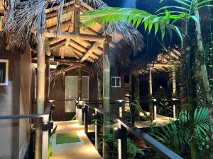 un edificio resort con techo de paja y pasarela en Subtropica Premium Suites - Mindo en Mindo