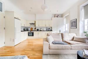 sala de estar blanca con sofá y cocina en GuestReady - Stunning hideaway in Central London en Londres