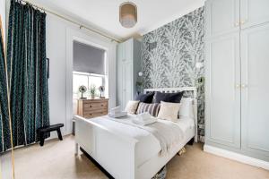 1 dormitorio con cama blanca y ventana en GuestReady - Stunning hideaway in Central London en Londres