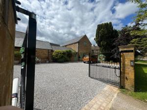 an open gate to a driveway in a house at The Old Stables in Northampton