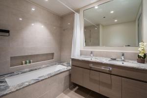 a bathroom with a tub and a sink and a mirror at GuestReady - Glamourous home in Downtown Dubai in Dubai
