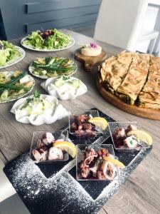 Kodra e Godenve في Vilë-Ballaj: طاولة مع العديد من أطباق الطعام والبيتزا