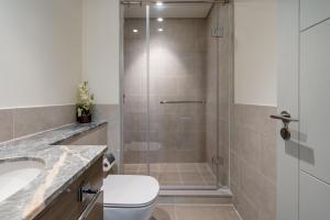 a bathroom with a shower with a toilet and a sink at GuestReady - Glamourous home in Downtown Dubai in Dubai
