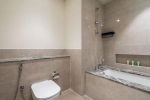 a bathroom with a toilet and a bath tub at GuestReady - Glamourous home in Downtown Dubai in Dubai