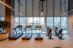 a gym with a row of exercise bikes in front of a large window at GuestReady - Glamourous home in Downtown Dubai in Dubai