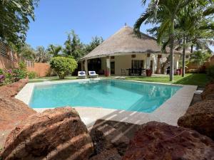 a swimming pool in front of a house at Agence Adjana Resort in Saly Portudal